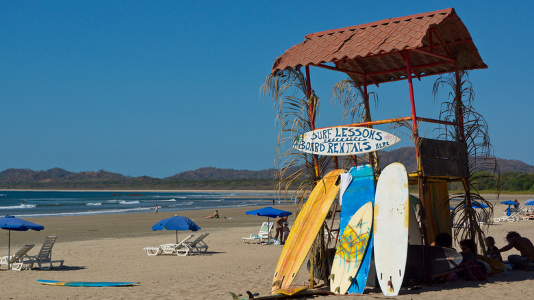 A surfboard shack and several beach chairs in Playa Tamarindo