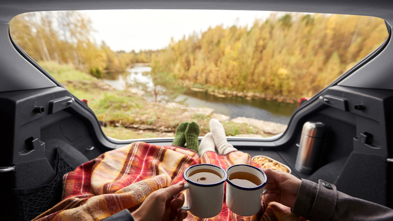 Blanket keeps couple warm however they enjoy autumn outdoor scenery