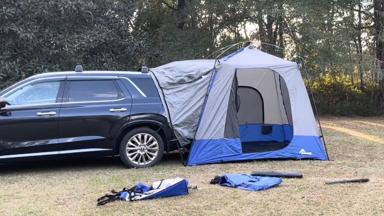 Napier Sportz Tent connected to a black SUV in the woods