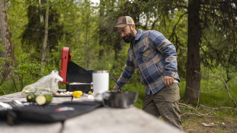 Caper as he prepares an outdoor portable barbecue grill