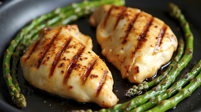 Close-up of grilled chicken breasts and asparagus with deep grill lines