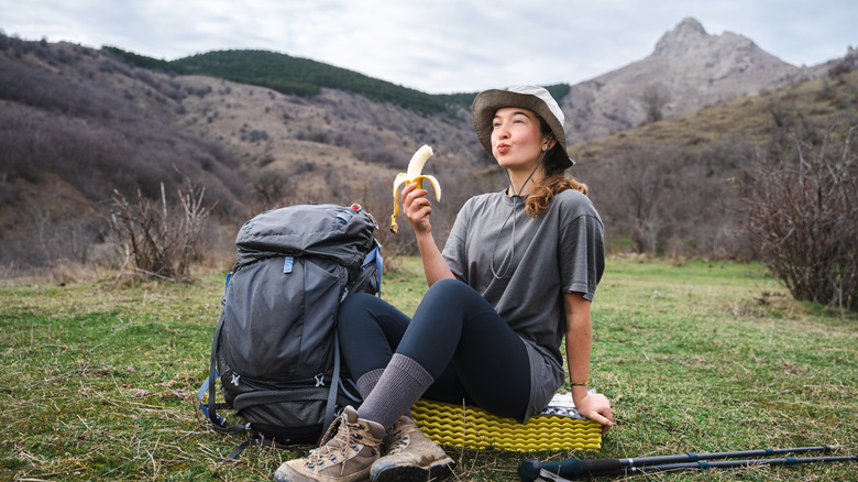 Woman takes a snack break on a hike