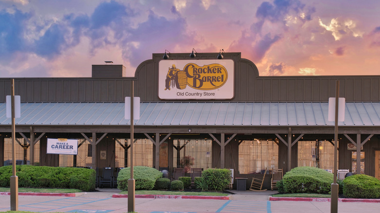 The storefront and porch of a Cracker Barrel at sunset