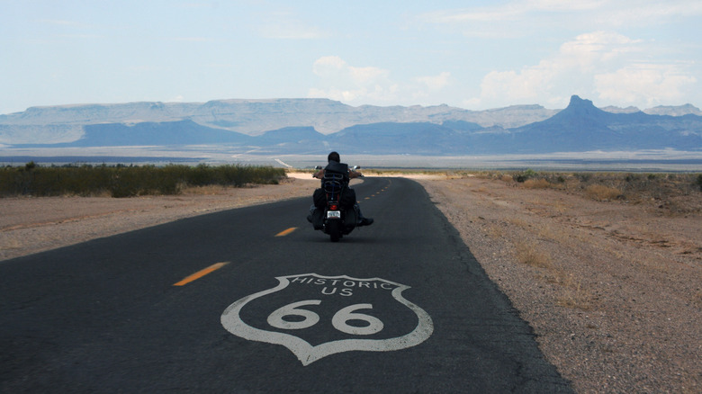 A biker riding with a view of the mountains on Route 66