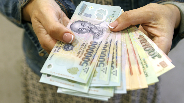 Woman holding Vietnamese banknotes