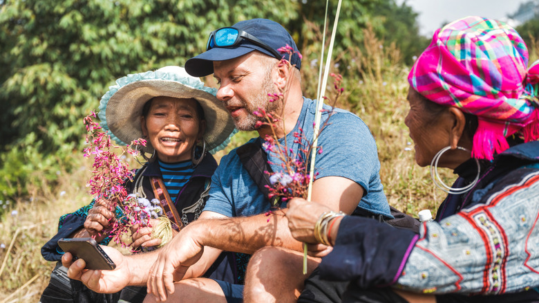 A tourist using a phone to talk to two women in Vietnam