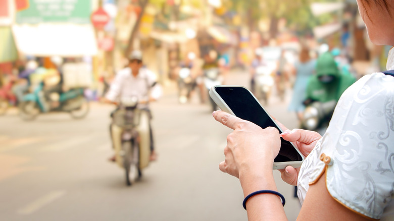 Woman using phone on Vietnamese street