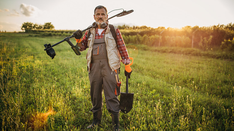 Man using metal detector in field