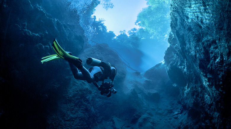 Diver swimming through Mexican cenote