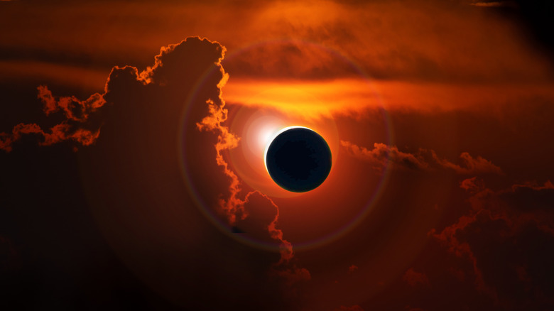 Total solar eclipse amidst orange skies