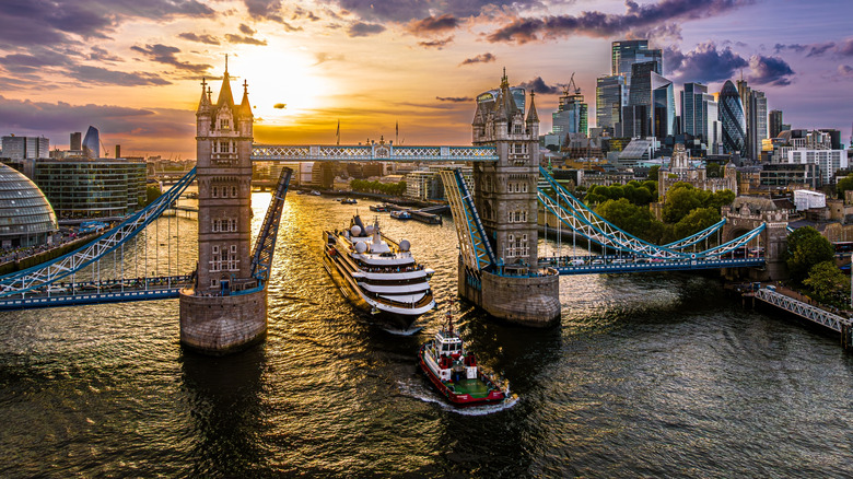 Aerial view of an Atlas Ocean Voyages ship departing London passing under the Tower Bridge