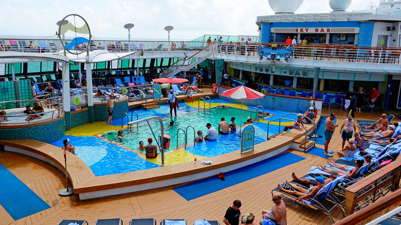 Guests in swimwear enjoying the pool deck of a Royal Caribbean ship