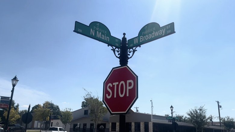 Green Broadway and Main street signs above stop sign