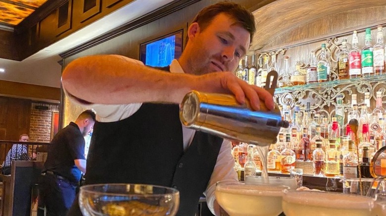 A bartender pouring drinks at the speakeasy Red Phone Booth in The Colony, Texas