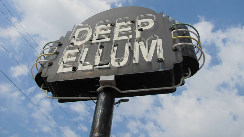 Neon sign against cloudy sky in Deep Ellum