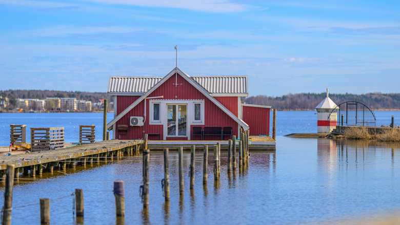 Floating red cabin attached to a pier on a Swedish lake in the Dalsland region.
