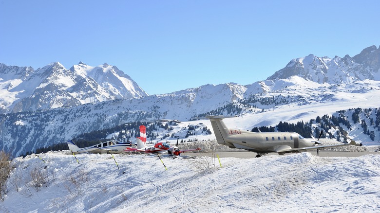 Planes standing at the snowy Courchevel Airport