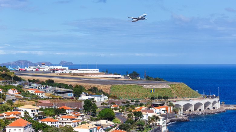 Plane flying over the oceanside Madeira Airport