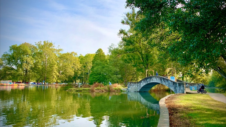 Eastwood MetroPark, near Downtown Dayton, Ohio, with a stone arched bridge over a body of water that reflects the surrounding foliage