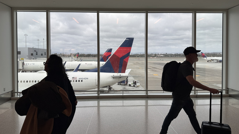 View of Delta aircraift from inside an airport corridor