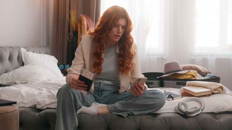 Frustrated traveler checking phone