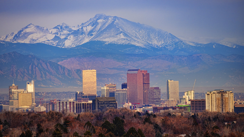 Skyline view of Denver, Colorado during a sunrise with the mountains in the background lightly covered in snow