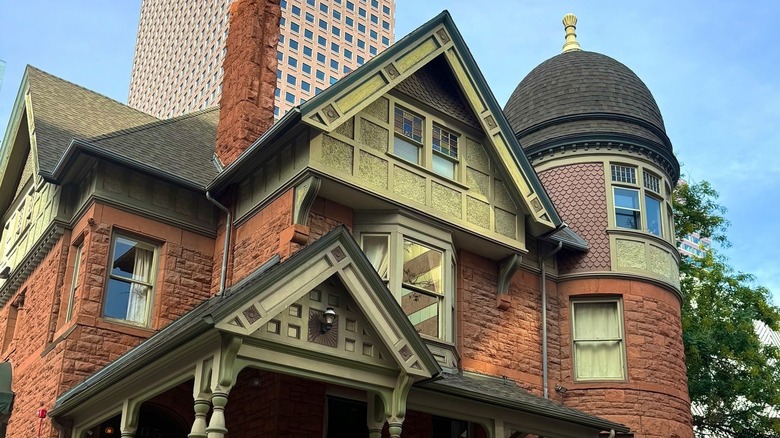 The exterior of the historic building with Denver skyline in the background on a sunny day