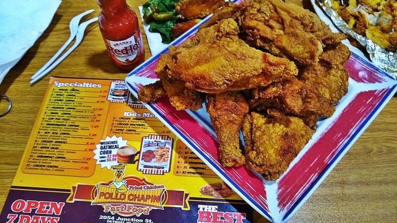 A plate of fried chicken with a Pollo Chapin menu