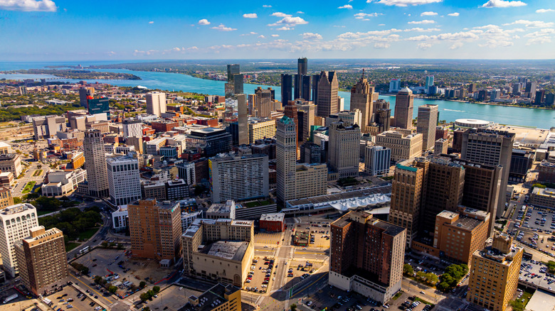 An aerial view of buildings in downtown Detroit, with the Detroit River in the background