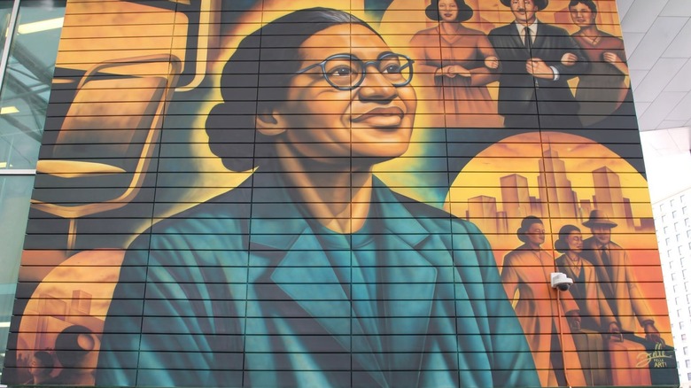A mural of Rosa Parks with Martin Luther King, Jr. and Coretta Scott King behind her