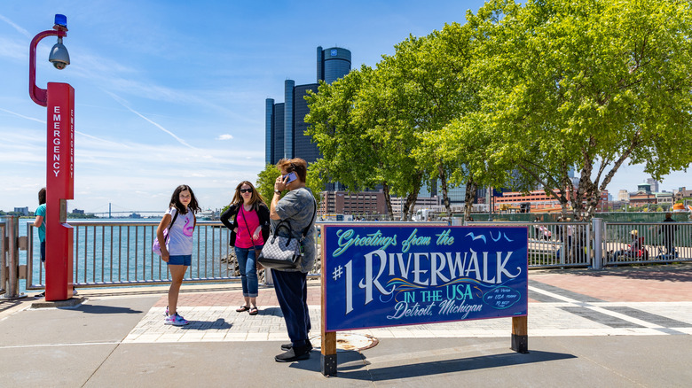 People stood near the Riverwalk sign in Detroit