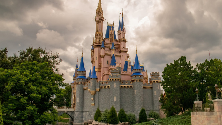Side view of the castle, the entrance to Magic Kingdom Park in Walt Disney World Resort, a theme park complex based in Orlando, Florida, USA, pictured on a gray, cloudy day