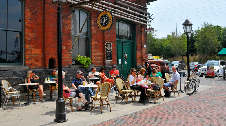 People eating at tables on the street of The Distillery District in Toronto, Canada