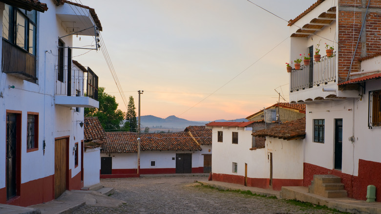 Sunrise over white houses in Tapalpa with mountains in the distance