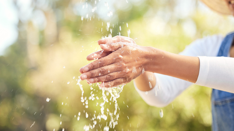 A woman washing her hands outside