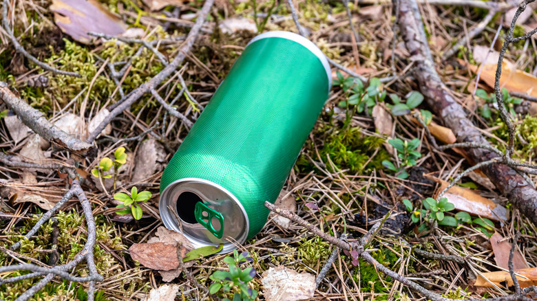 Empty green can on the forest floor