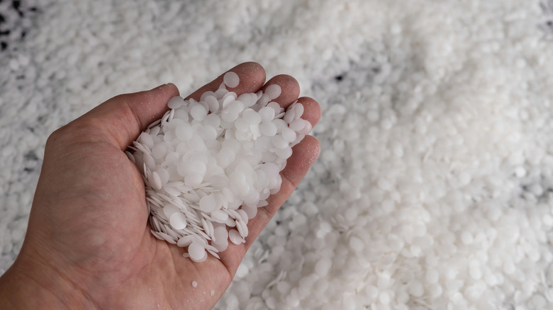 Hand holding white wax beads