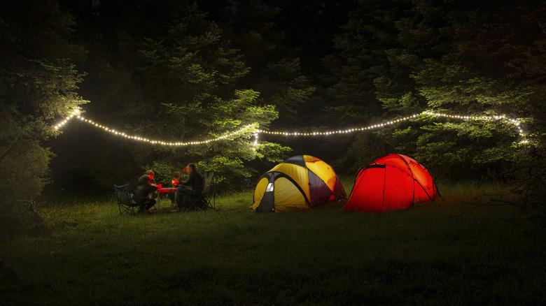 Neon camp tents surrounded by fairy lights