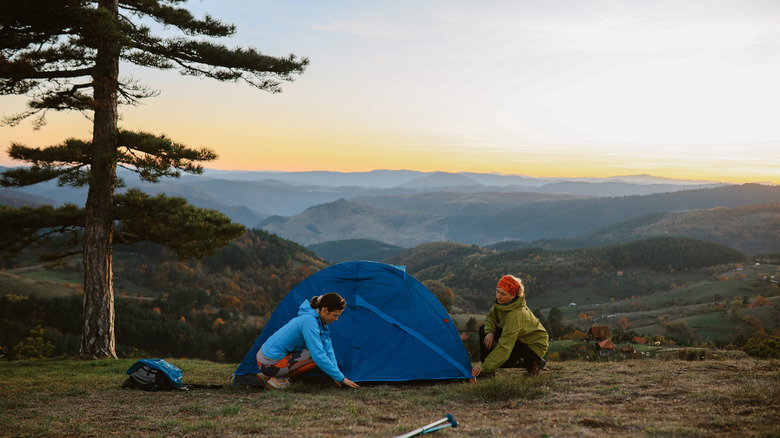 A couple of campers setting up a tent on a camping trip