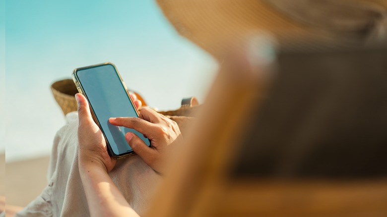 Person using a smartphone at the beach 