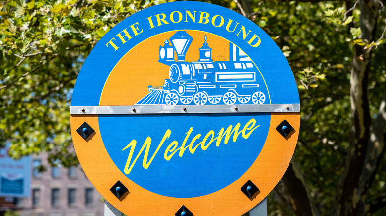 Blue and Yellow "Welcome to Ironbound" sign with a train on it