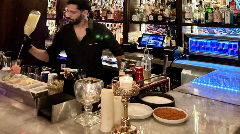 A bartender pours drinks at Sinners y Santos in Level 8