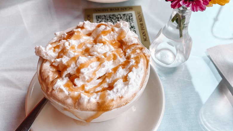 A caramel topped cappuccino on a white table cloth at Cafe Intermezzo in Nashville