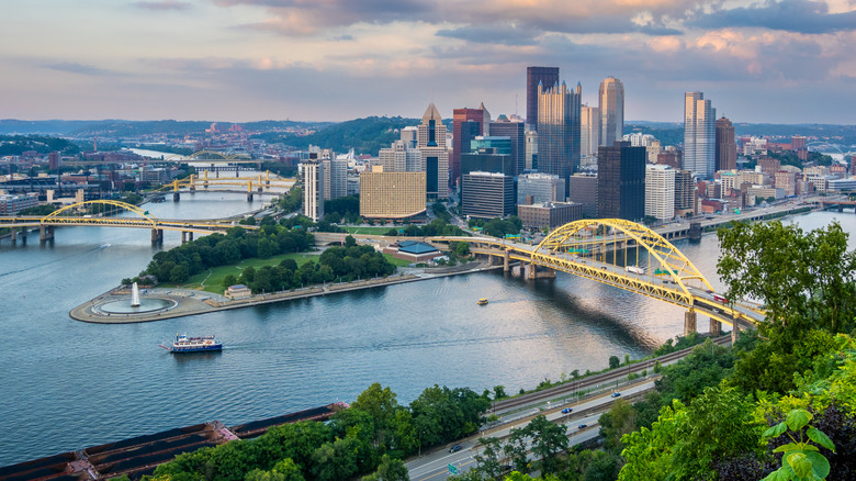 Downtown Pittsburgh, with the Point fountain and confluence of the three rivers in front of the skyline under a cloudy sky