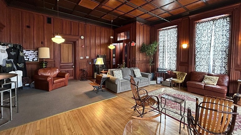 Great Room at the Traveler's Rest, with couches and chairs around a rug on a wooden floor, surrounded by dark wood walls