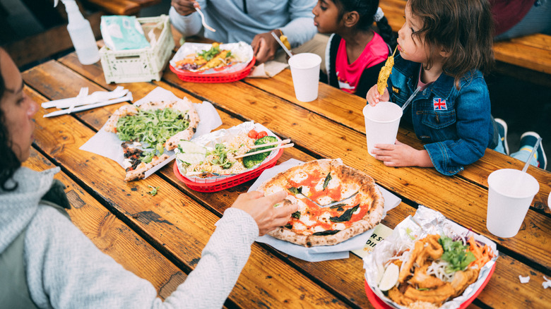 People eating at a food truck pod in Portland, Oregon