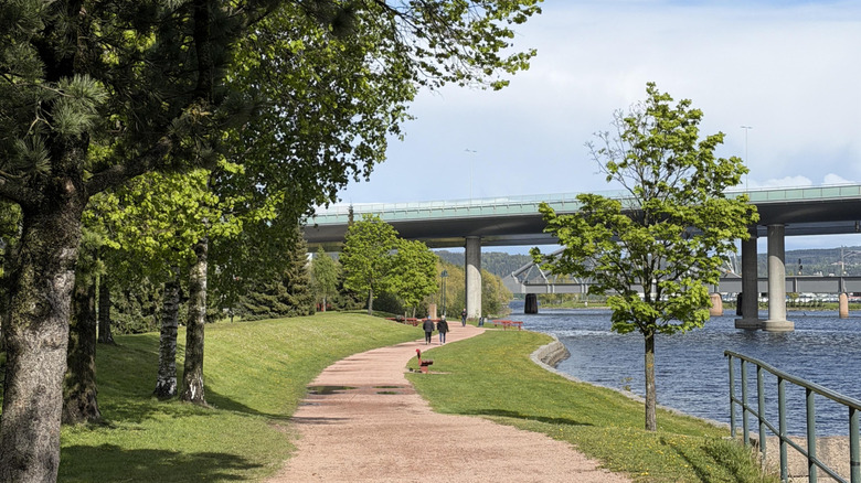 A pedestrian riverfront walkway winding along the Drammen River in Drammen, Norway