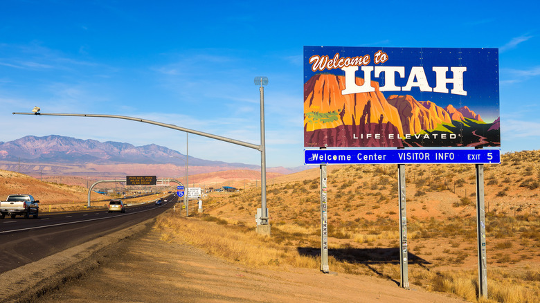 I-15 freeway leading into red rocks with Welcome to Utah sign