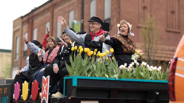 People wearing traditional Dutch garb on a parade float with tulips in Holland, Michigan