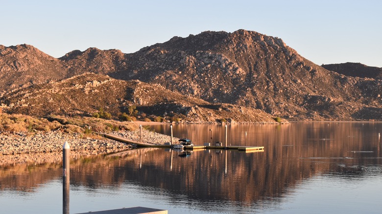 California's Lake Perris State Recreation Area at sunset, with a boat ramp and mountains in the background